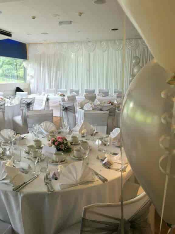 Clubhouse wedding reception with elegant balloon decor and formal banquet table settings.