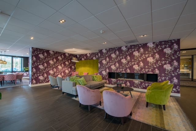 Modern hotel lobby with lounge seating and fireplace for networking and small-group meetings.