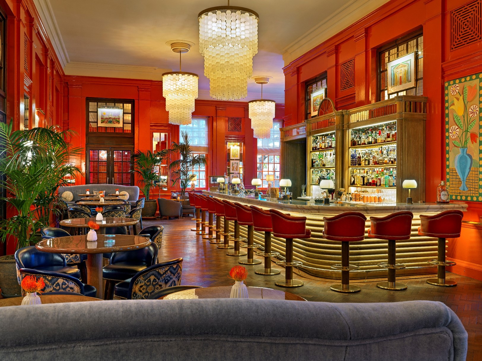 Upscale Coral Room bar with vibrant red walls, ideal for cocktail receptions and networking. - Banner