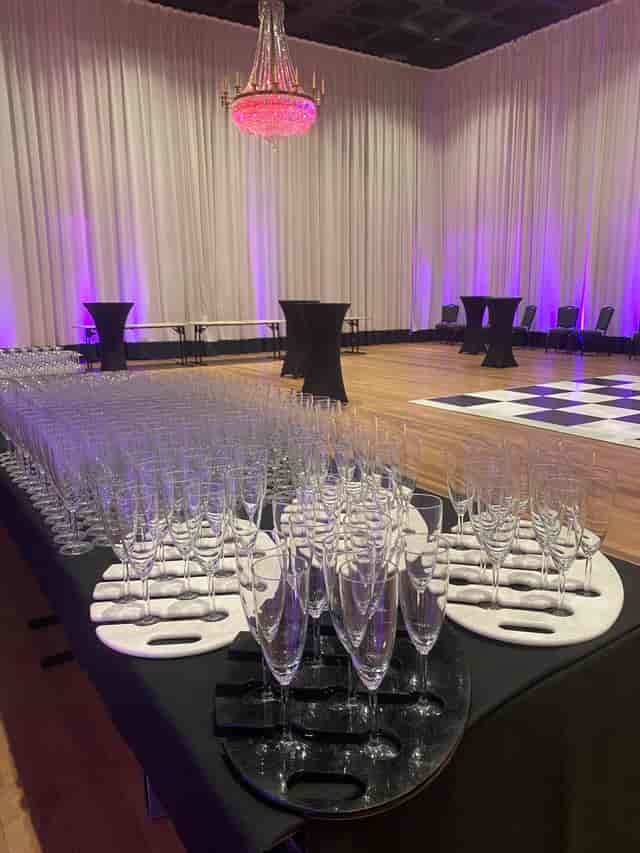 Cocktail reception setup in Glaziers Hall with elegant glassware and purple lighting