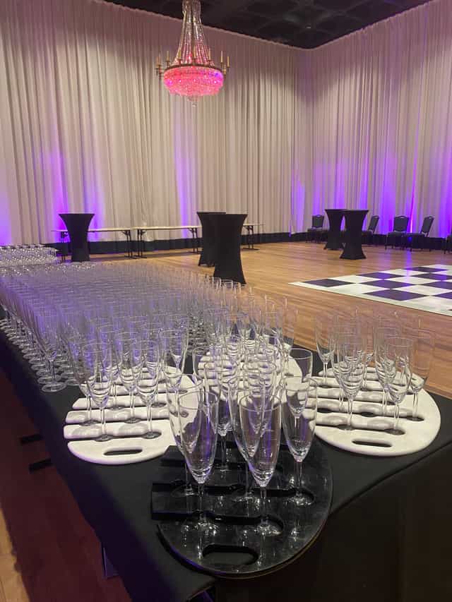 Cocktail reception setup in Glaziers Hall with elegant glassware and purple lighting