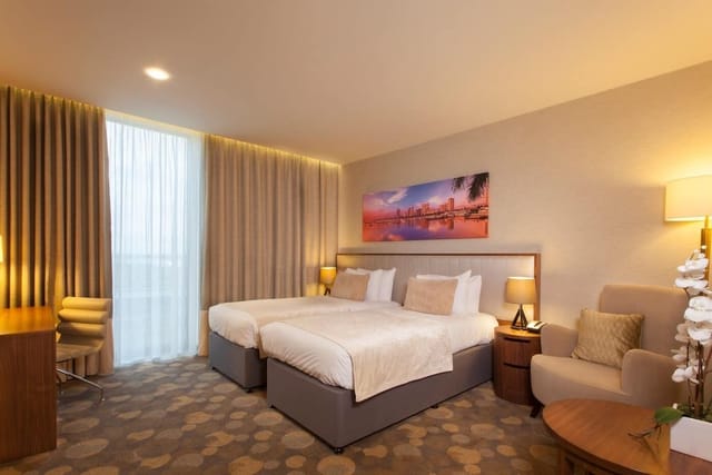 Twin guest room at Genting Hotel with workspace for corporate group bookings and events.