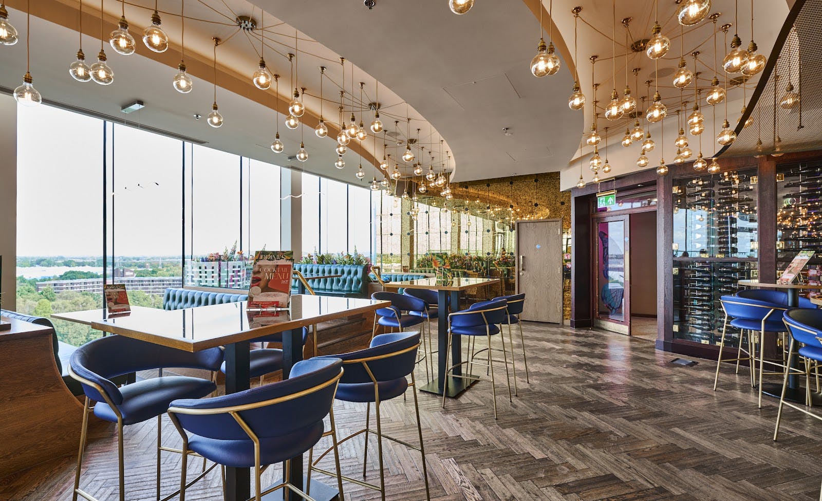 Upscale cocktail bar with floor-to-ceiling windows for networking and corporate events. - Banner