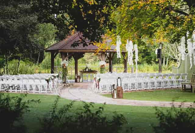 Outdoor wedding gazebo at Moddershall Oaks with white chairs for elegant ceremony venue setup.