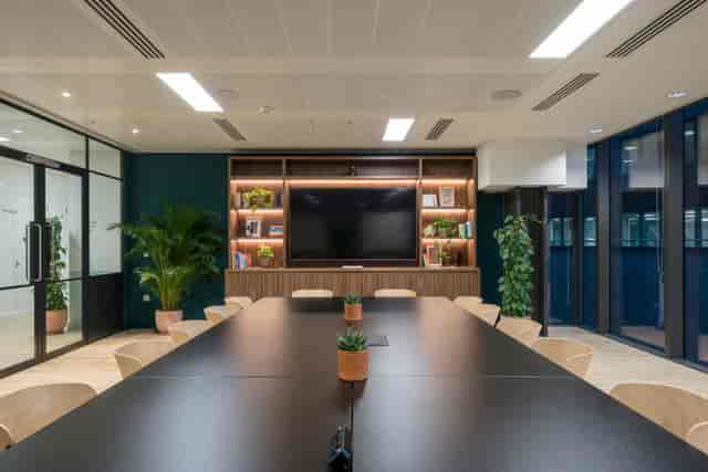 Professional boardroom for executive meetings and hybrid client pitches with integrated AV tech.