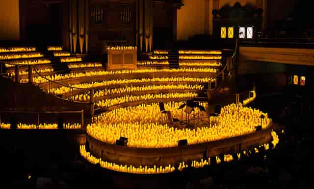 Auditorium in Central Hall Westminster with candlelit tiered seating for an intimate concert.