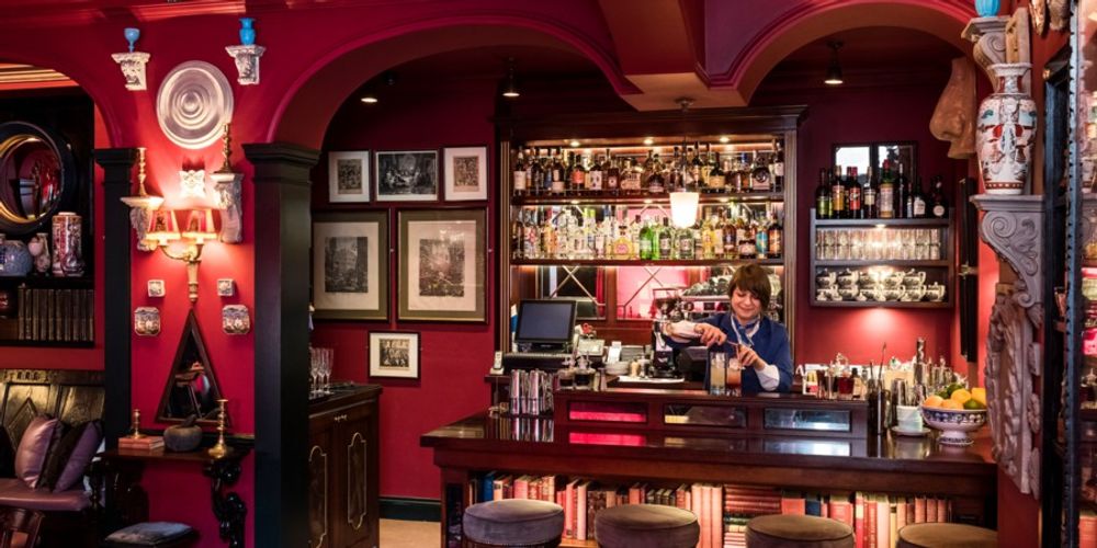 Cozy cocktail bar with rich red walls, ideal for intimate gatherings and networking.