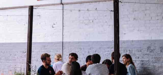 Industrial-chic event venue with white brick wall for networking and corporate breakout sessions.