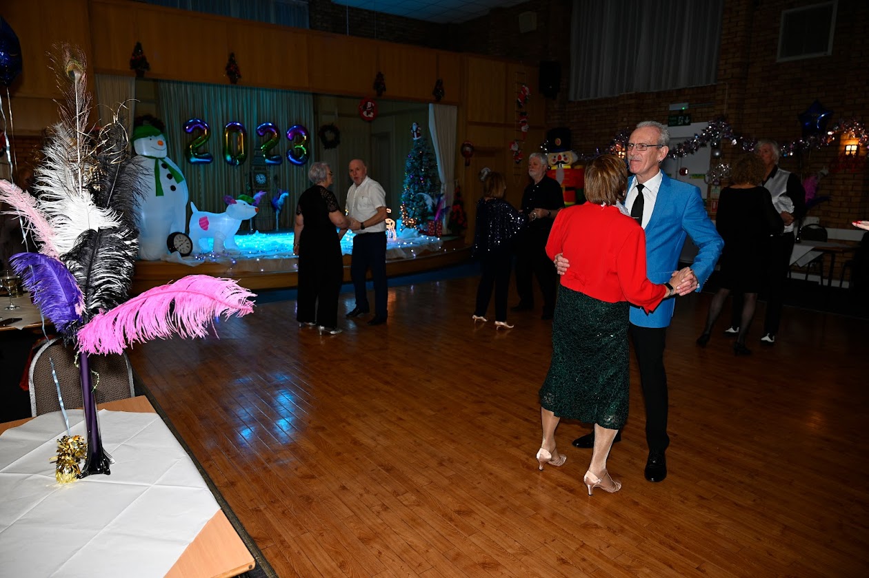 Community dance party in function room with festive DIY decor for end-of-year celebration event.