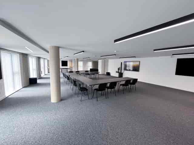 U-shaped boardroom in minimalist conference space, perfect for corporate meetings and workshops.