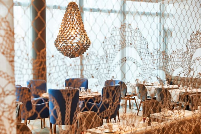 Upscale Steigenberger Hotel Munich dining space with velvet seating for corporate lunch and events.