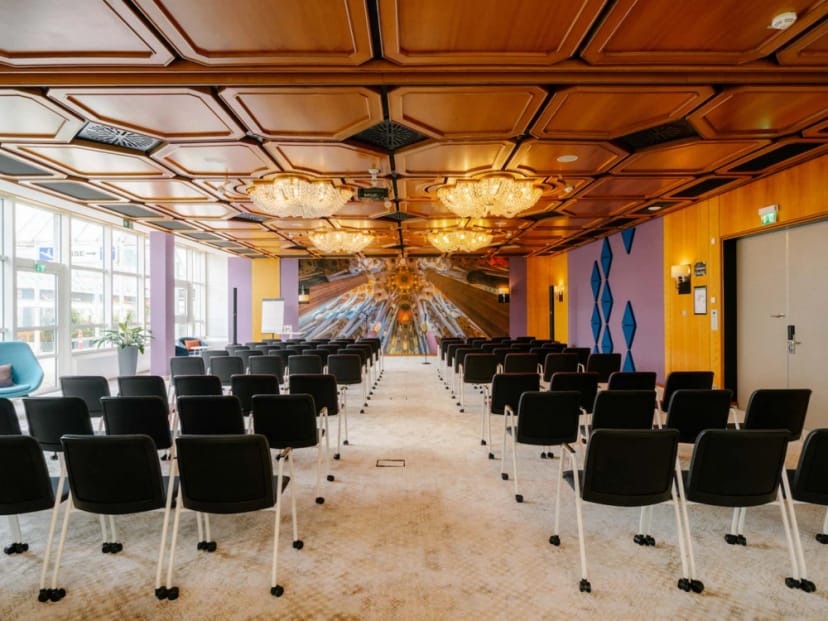 Retro event space with coffered wooden ceiling for theater-style corporate meetings and workshops.