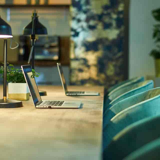 Upscale velvet hot desk workspace with lush greenery for collaborative breakout sessions.