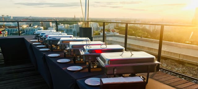 Rooftop banquet at Upside East with golden hour skyline, luxury event catering.