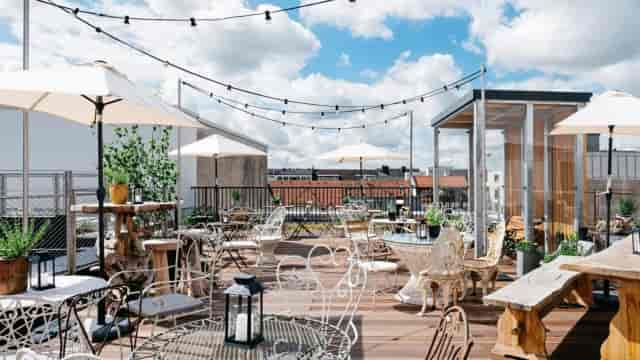 Chic rooftop terrace with bistro lighting for corporate networking and social events.
