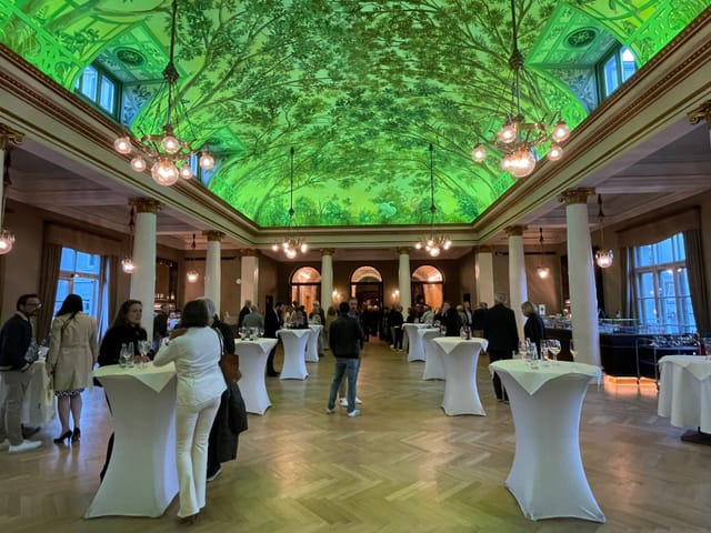 Projection mapping in Prinzregententheater ballroom for corporate networking event.