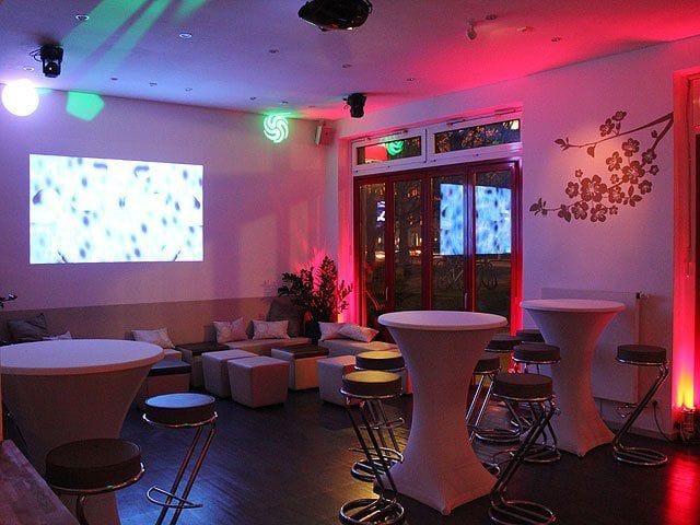 Modern event space at Oberangertheater with high-top tables for corporate networking receptions.