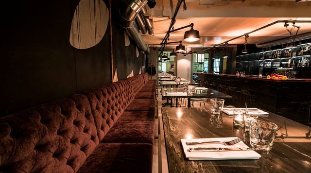 Industrial restaurant for corporate receptions and post-conference dinners with banquette seating.