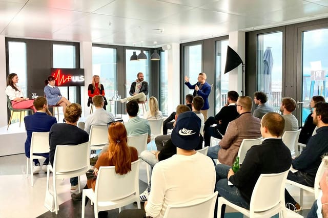 Corporate panel discussion at Raum Scribble, DECK7, featuring modular seating for professional events.