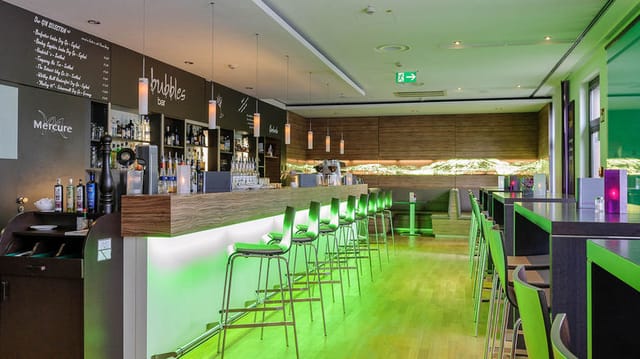 Modern hotel bar with high-top seating, ideal for corporate networking and brand activation events.