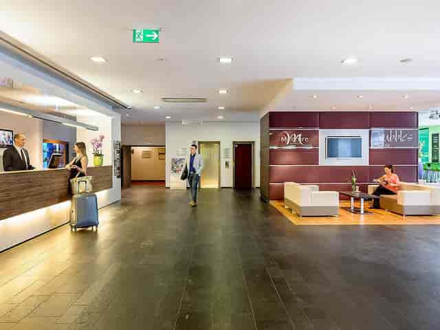 Modern hotel lobby at Starnberger See, check-in area for business meetings and corporate events.