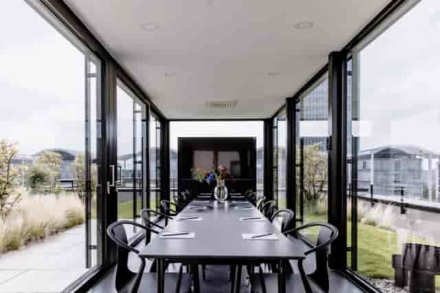 Glass-enclosed rooftop boardroom at THE FLAG München M for executive strategy sessions.