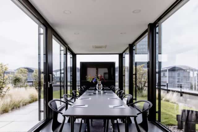 Glass-enclosed rooftop boardroom at THE FLAG München M for executive strategy sessions.