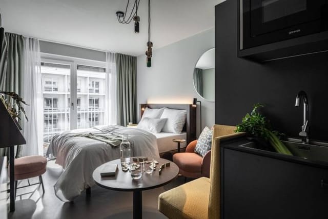 Modern Revo Munich guest room for bleisure travel, remote work, and business meetings.
