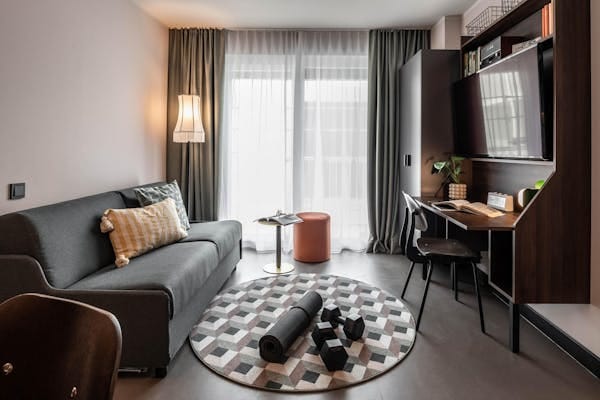 Modern Revo Munich hotel room with workspace for bleisure travel and business accommodation.