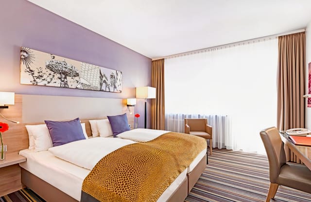 Modern hotel room with workspace for corporate business travel and twin beds.