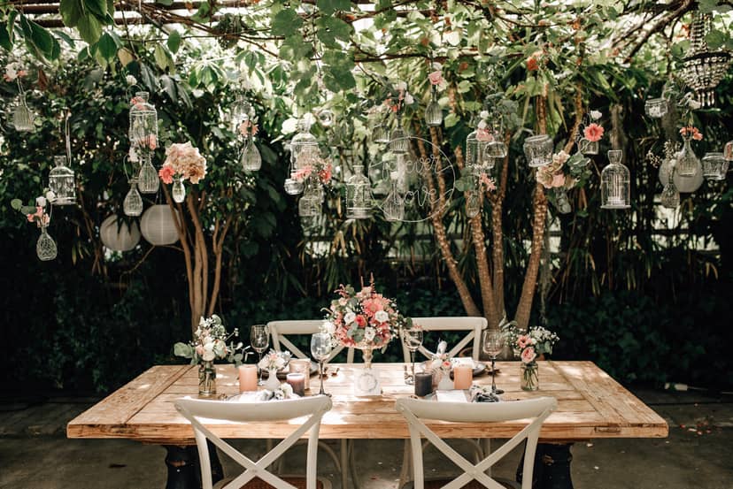 Greenhouse wedding tablescape with hanging glass vessels for upscale event decor.