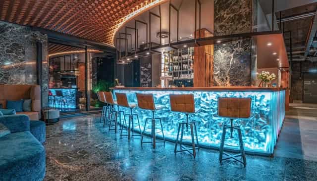 Backlit bar in Unsöld's Factory Hotel lounge for VIP networking and corporate cocktail receptions.
