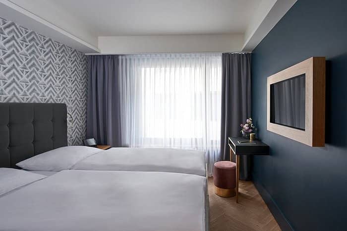 Modern twin guest room at AMANO Bar Munich for corporate lodging and business event accommodation.