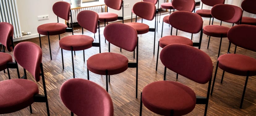 Disorganized theater-style seating at a Der Raum seminar, event planning example.