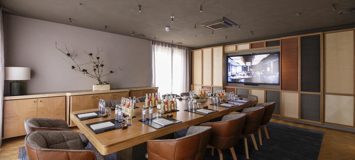 Executive boardroom at LOUIS Hotel with A/V setup for private dining and corporate events.