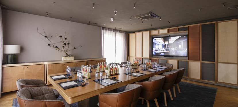 Executive boardroom at LOUIS Hotel with A/V setup for private dining and corporate events.
