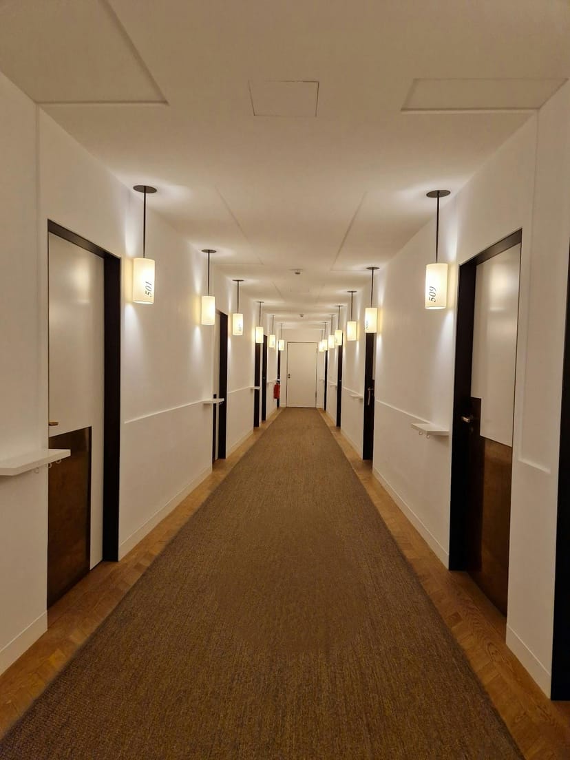 Narrow, sterile hotel corridor at LOUIS Hotel, ideal for functional lodging and event accommodation.