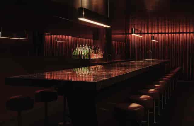 Luxury cocktail bar lounge with linear lighting for VIP receptions and networking events.