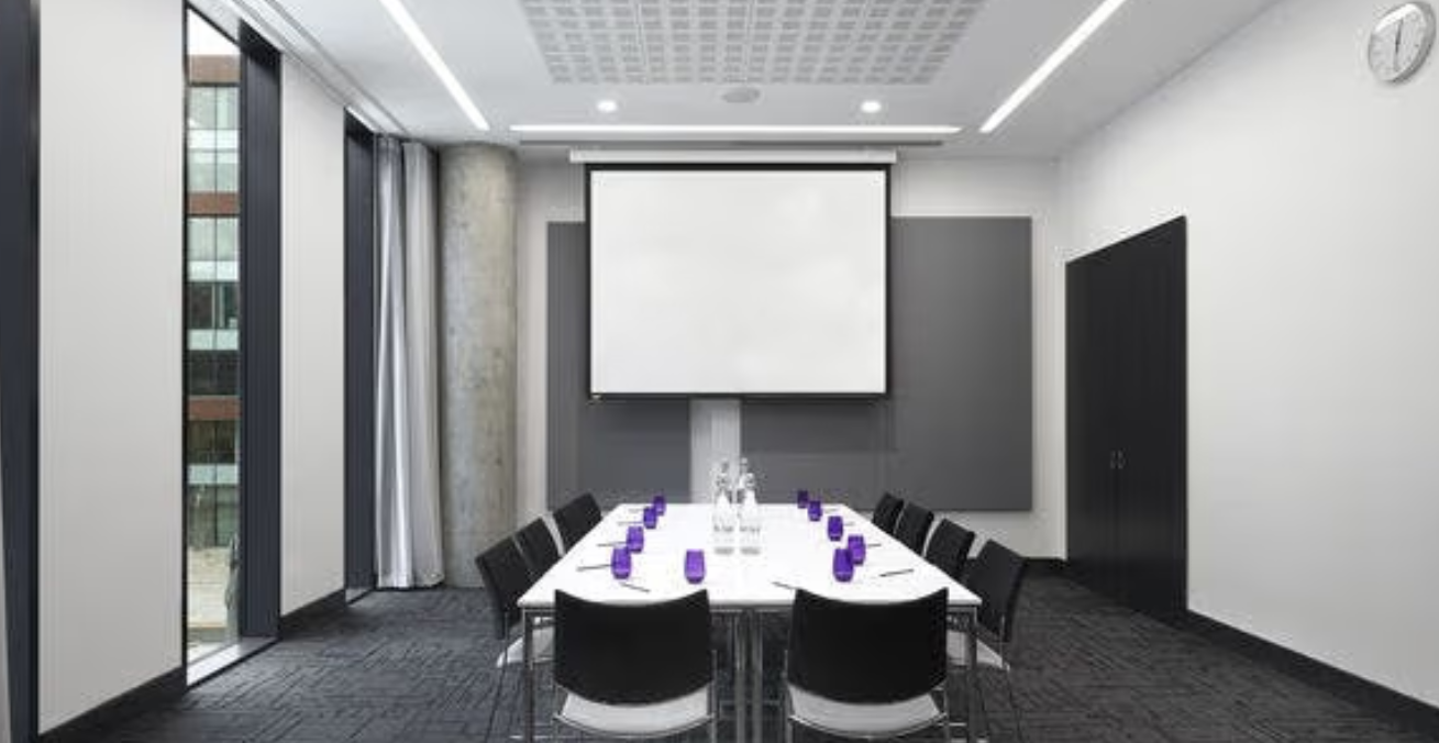 Modern meeting room in INNSIDE Manchester, ideal for presentations and professional gatherings. - Banner