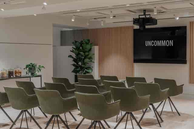 Modern meeting room with large screen and seating, ideal for events and presentations.