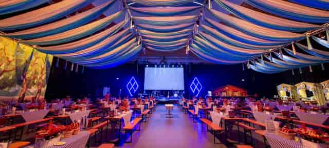 Ballhausforum main stage with ceiling draping and uplighting for corporate event and gala venue.