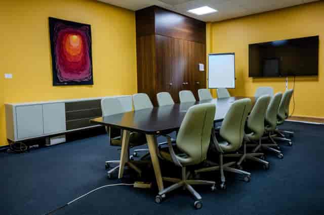 Salle Mandarine boardroom with yellow walls, ideal for corporate meetings and breakout sessions.