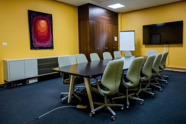 Salle Mandarine boardroom with yellow walls, ideal for corporate meetings and breakout sessions.