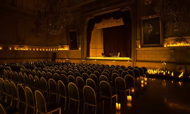 Concert Noble hall with candlelit theater setup for exclusive keynote or corporate fireside chat.
