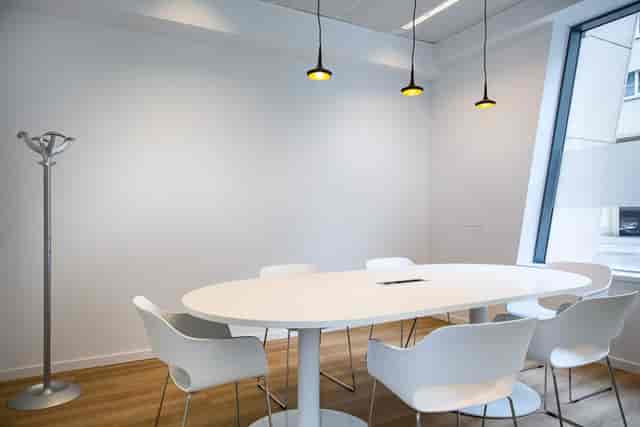 Minimalist breakout room with oval table for intimate brainstorming and private meetings.