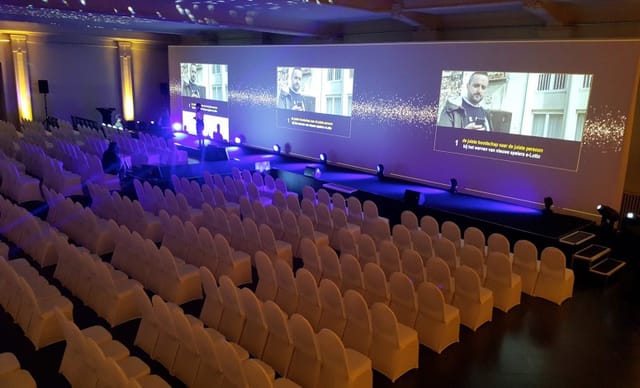 Plenary setup at Albert Hall Brussels: wide-screen projection, theater seating for corporate events.
