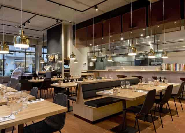 Modern restaurant for corporate networking and team lunch with open-kitchen seating.