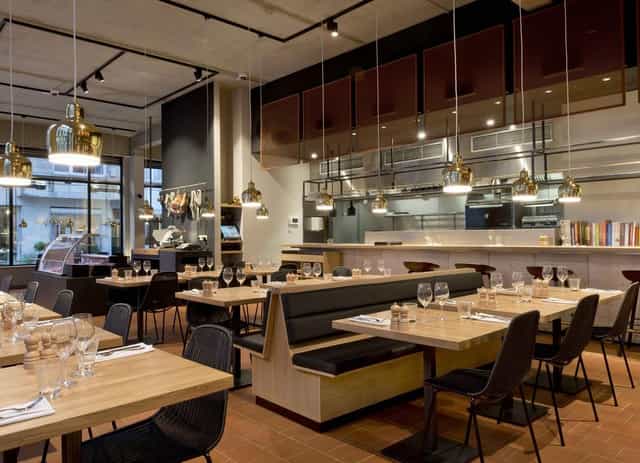 Modern restaurant for corporate networking and team lunch with open-kitchen seating.