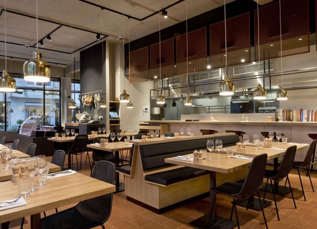 Modern restaurant for corporate networking and team lunch with open-kitchen seating.