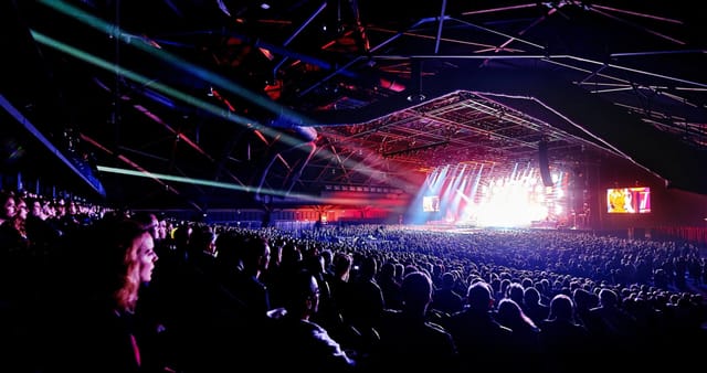 ING Arena concert hall with theater-style seating, dramatic lighting, and large IMAG screens.